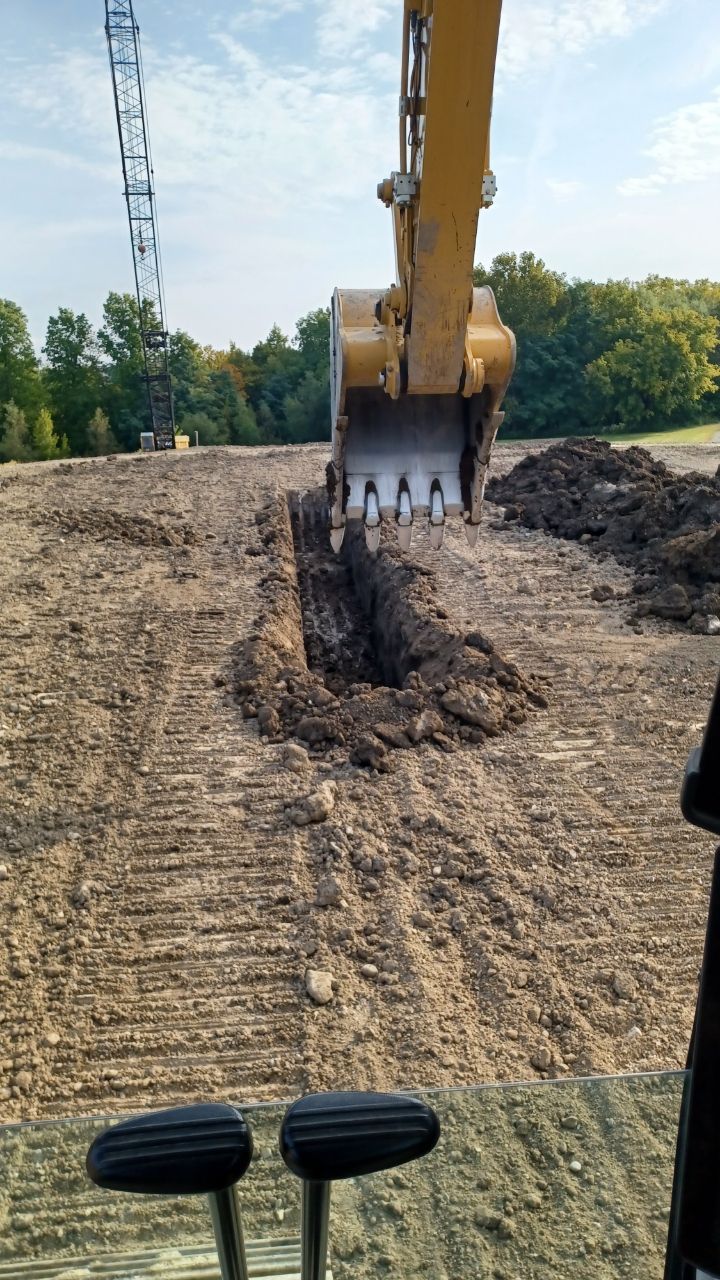 A bulldozer is digging a hole in a dirt field.