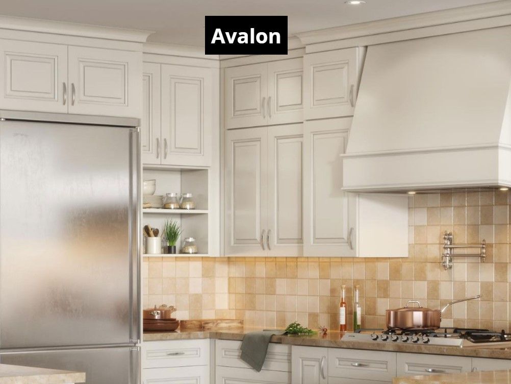 A kitchen with white cabinets and a stainless steel refrigerator