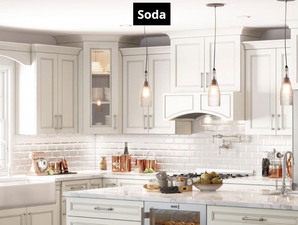 A kitchen with white cabinets , a stove , a sink , and a large island.