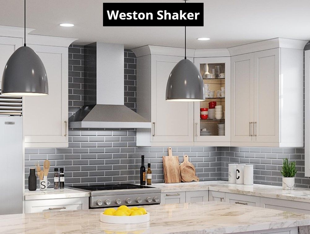 A kitchen with white cabinets , a stove , a refrigerator , and a hood.