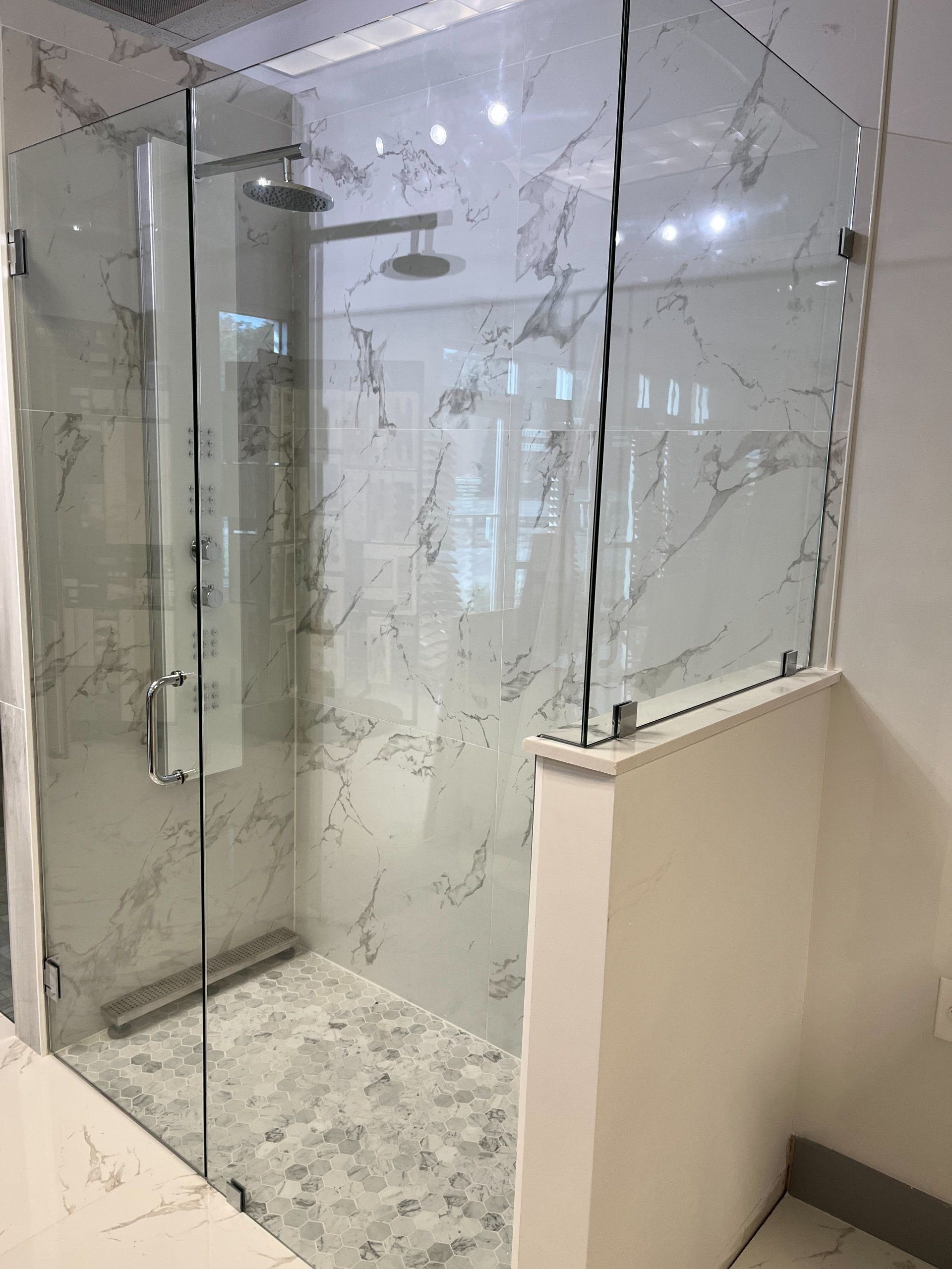 A bathroom with a walk in shower with a glass door.