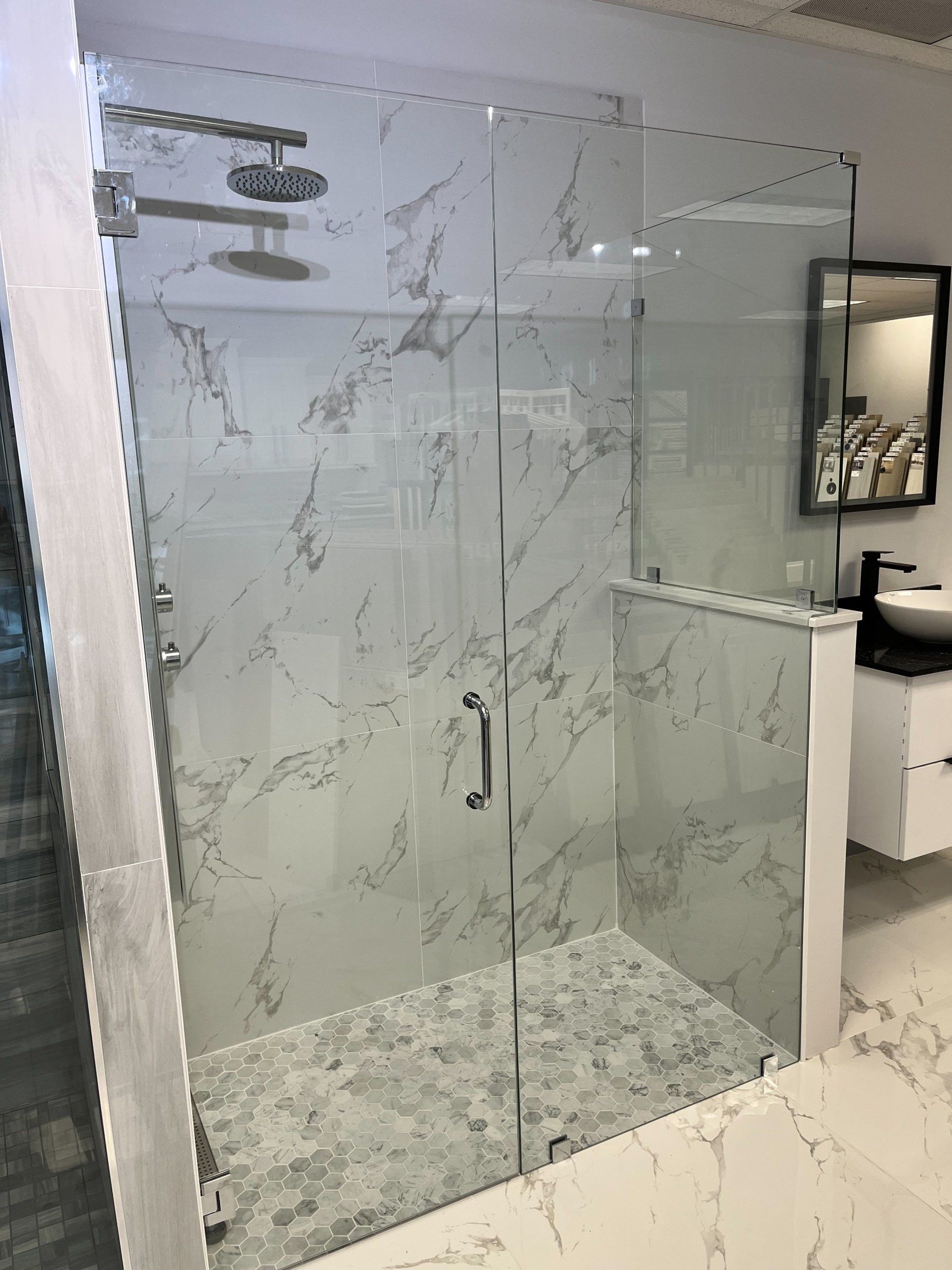 A bathroom with a walk in shower and a sink.