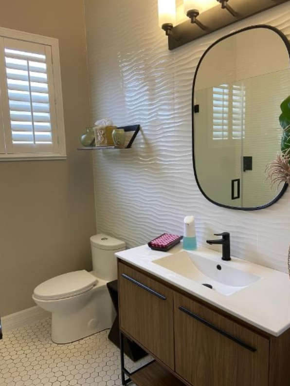 A bathroom with a toilet , sink and mirror