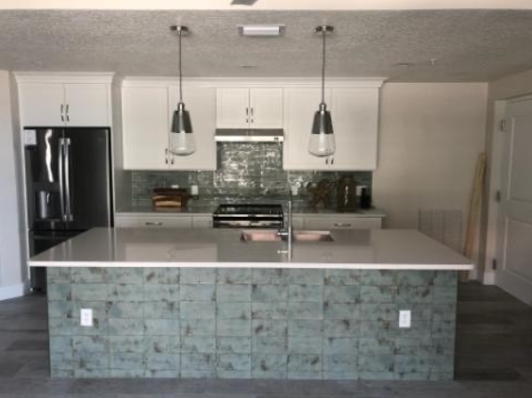 A kitchen with a large island and white cabinets
