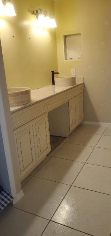 A bathroom with two sinks and a washer and dryer.