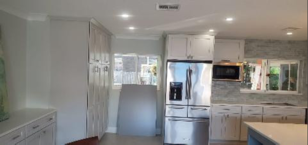 A kitchen with stainless steel appliances and white cabinets.