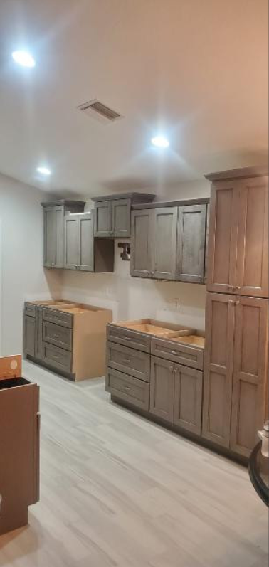 A kitchen with gray cabinets and white floors is being remodeled.