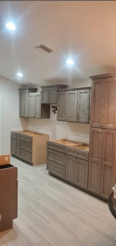 A kitchen with gray cabinets and white floors is being remodeled.
