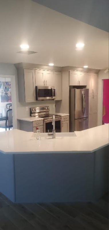 A kitchen with stainless steel appliances and white cabinets.