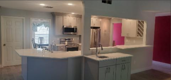 A kitchen with white cabinets and stainless steel appliances.