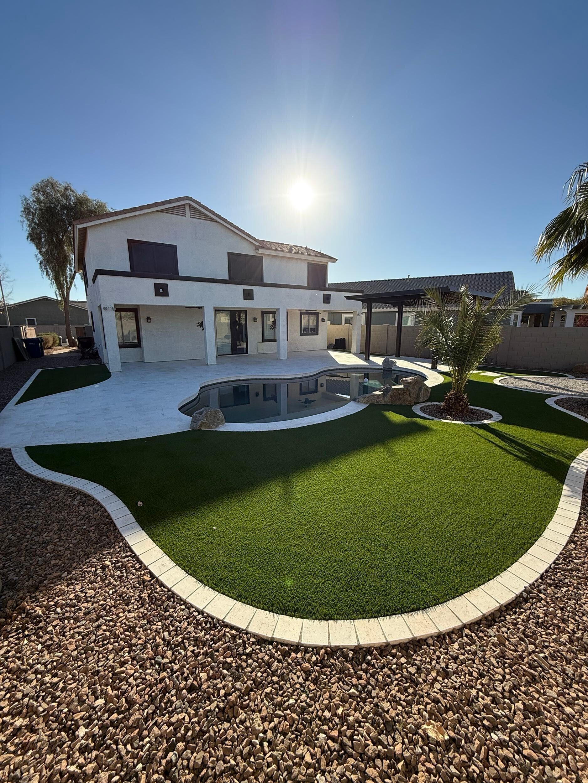 A large white house with a swimming pool in the backyard.