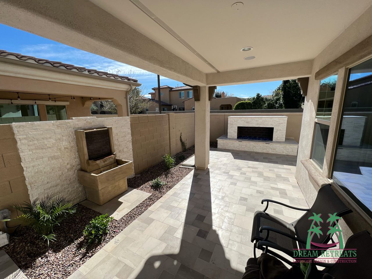 A patio with a fireplace and a chair with a palm tree logo on it