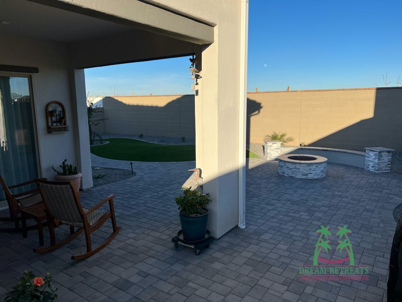 A rocking chair is sitting on a patio next to a fire pit.