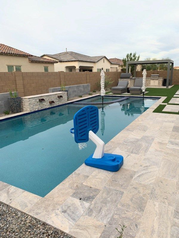 A blue basketball hoop sits on the edge of a swimming pool