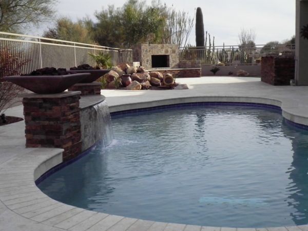 A large swimming pool with a waterfall in the middle