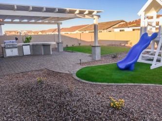 A backyard with a pergola and a blue slide