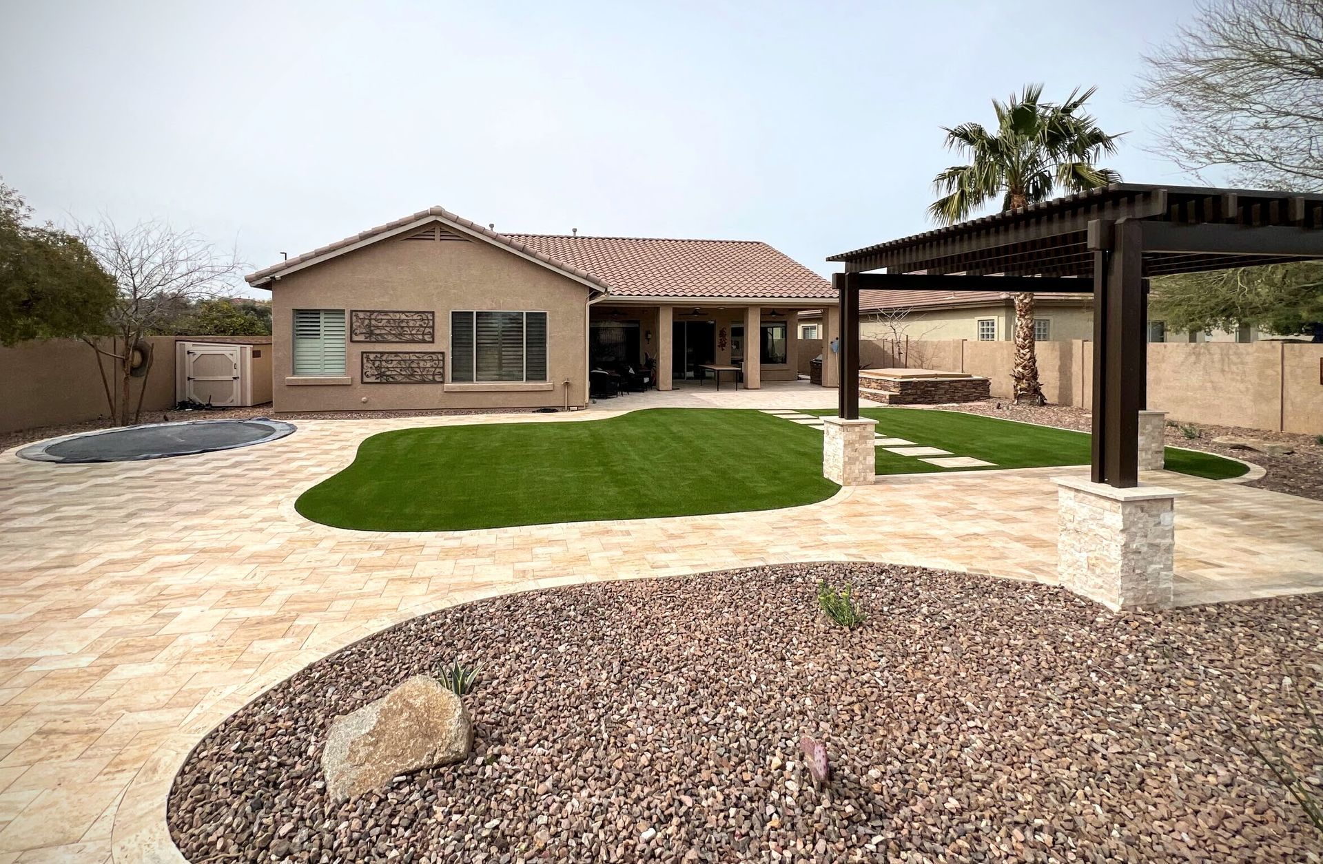 A house with a large lawn and a pergola in the backyard