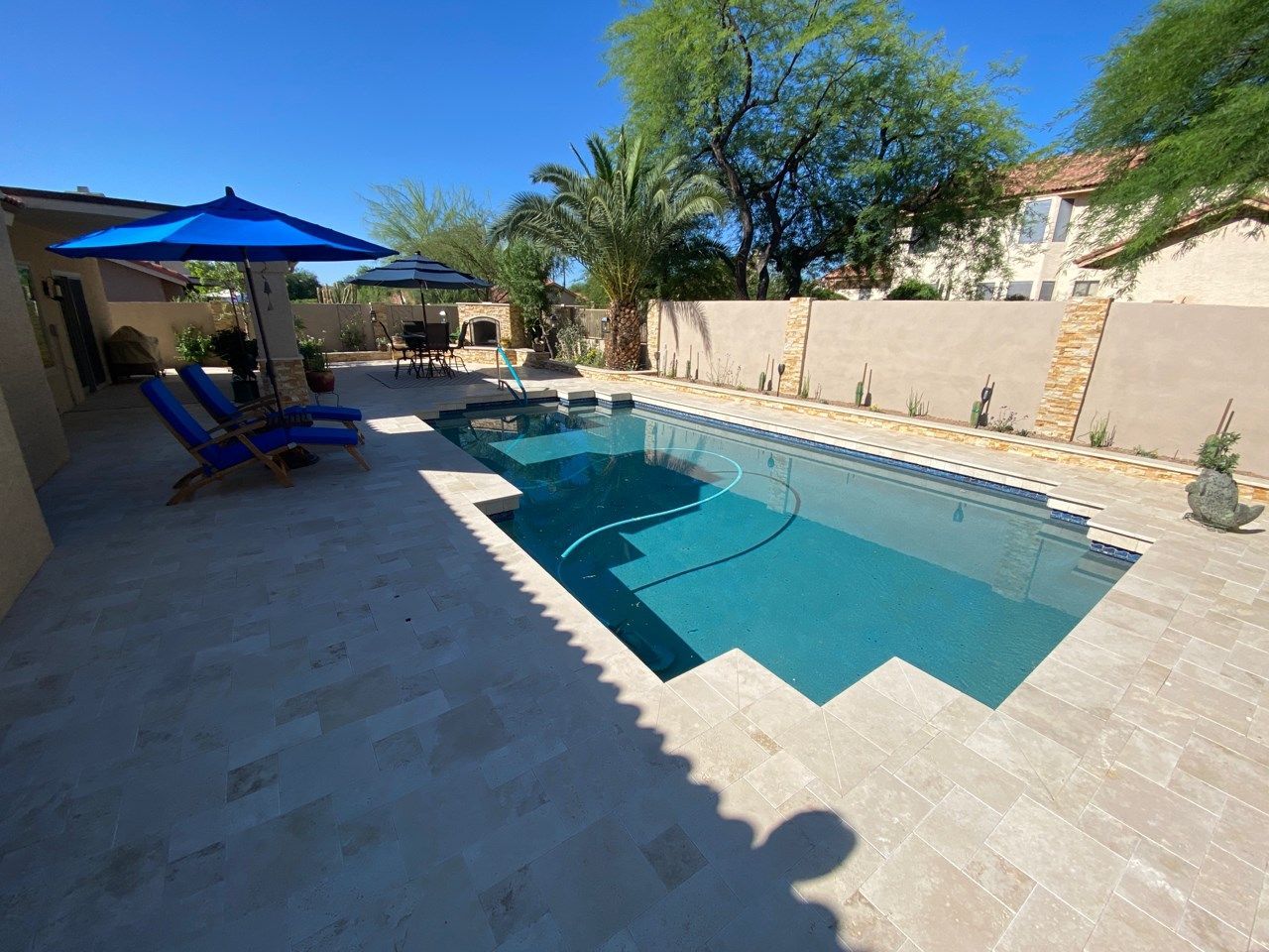 A large swimming pool surrounded by chairs and umbrellas