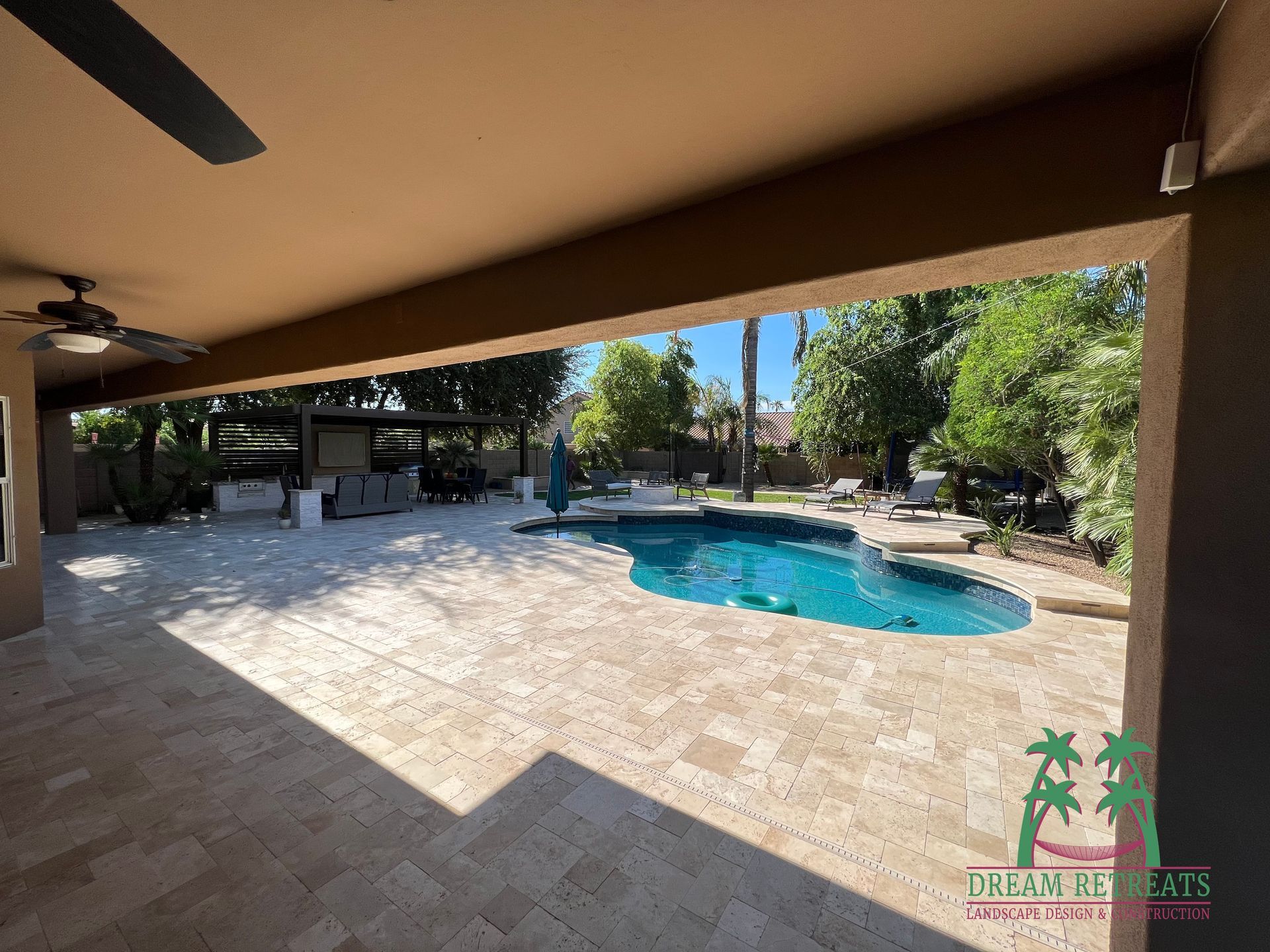There is a large swimming pool in the backyard of a house.