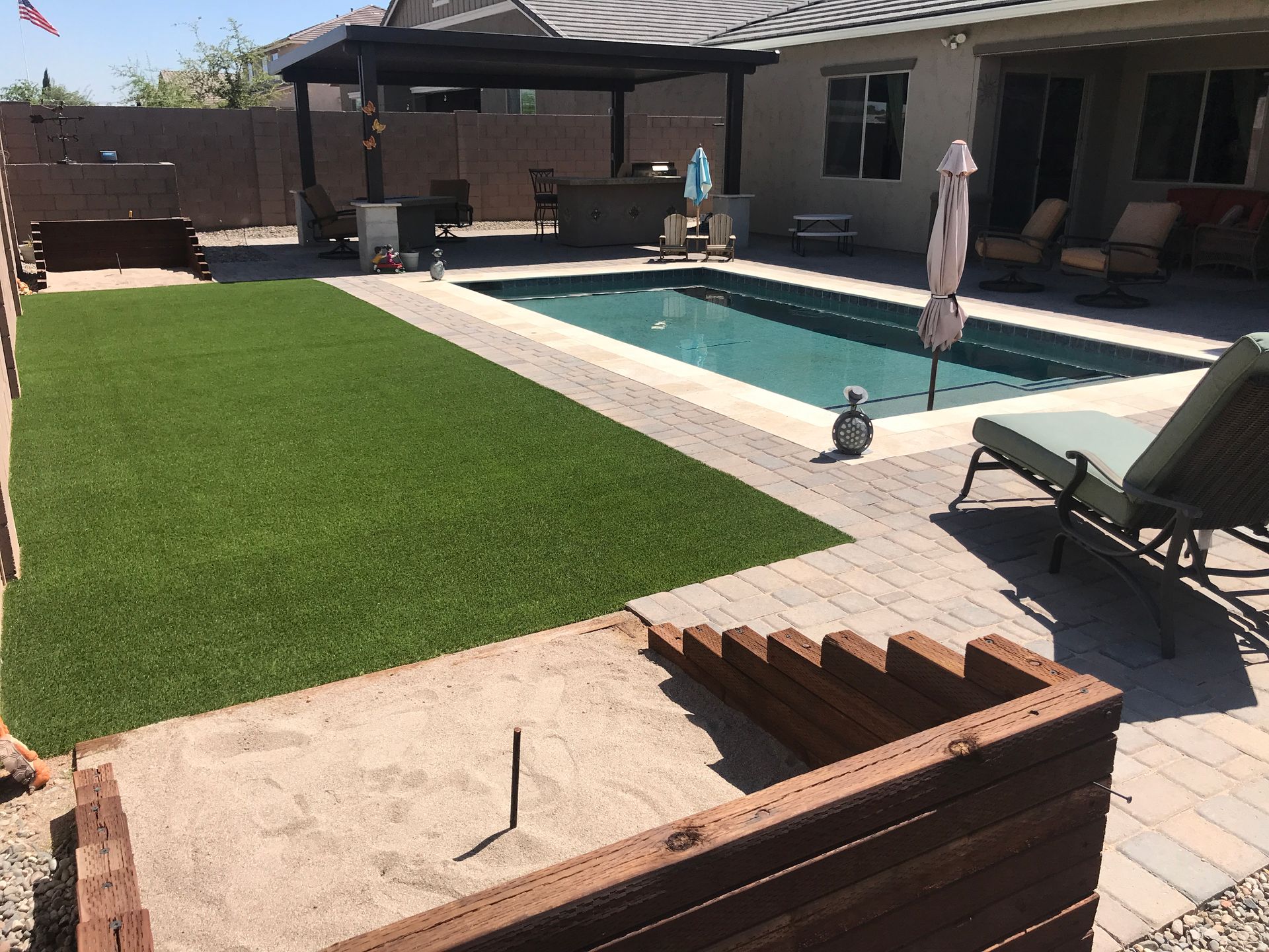 A large swimming pool is in the backyard of a house.