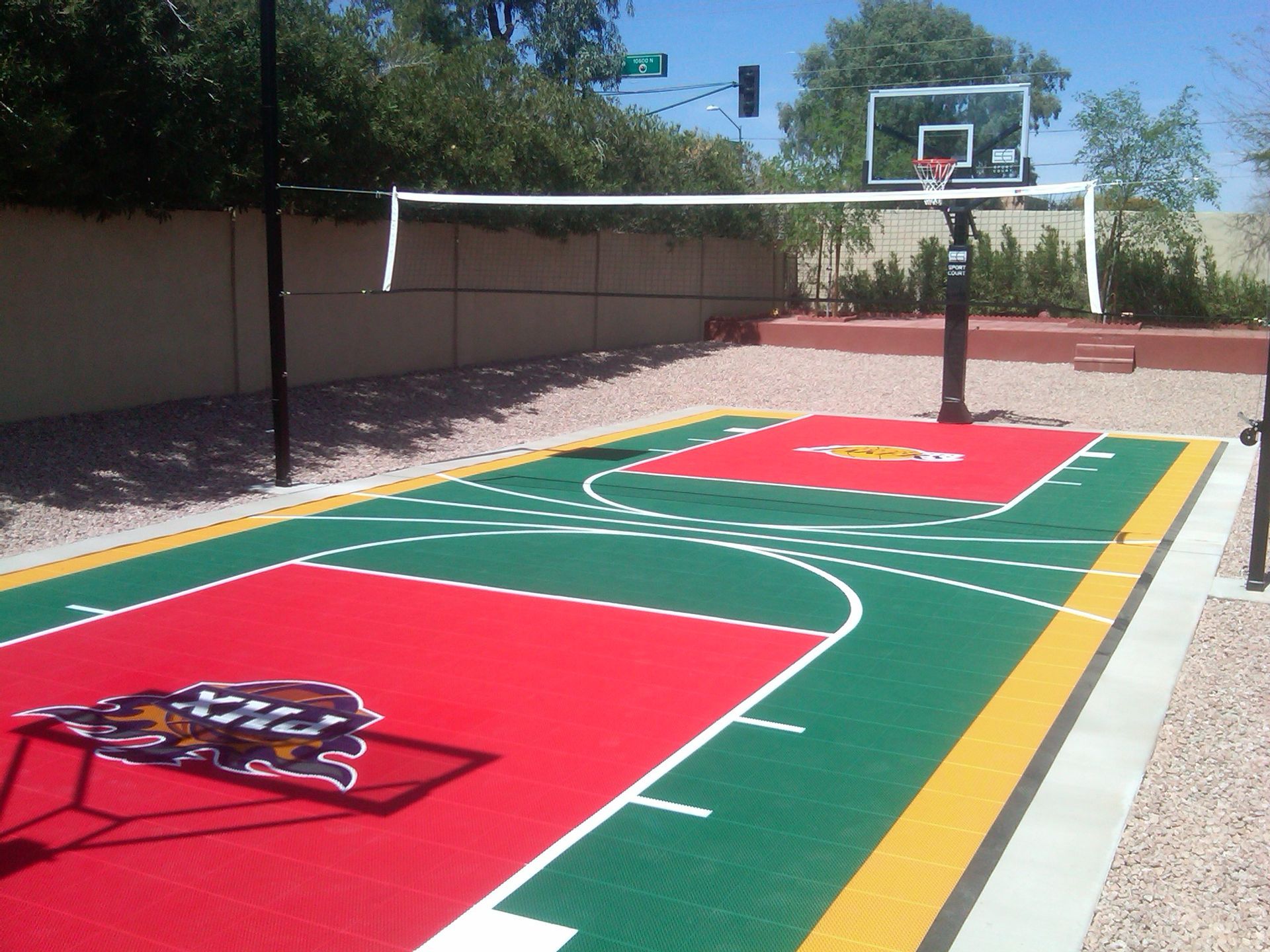 A basketball court with a volleyball net and a basketball hoop