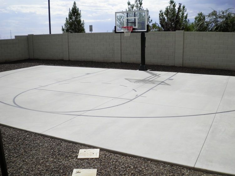 A concrete basketball court with a basketball hoop