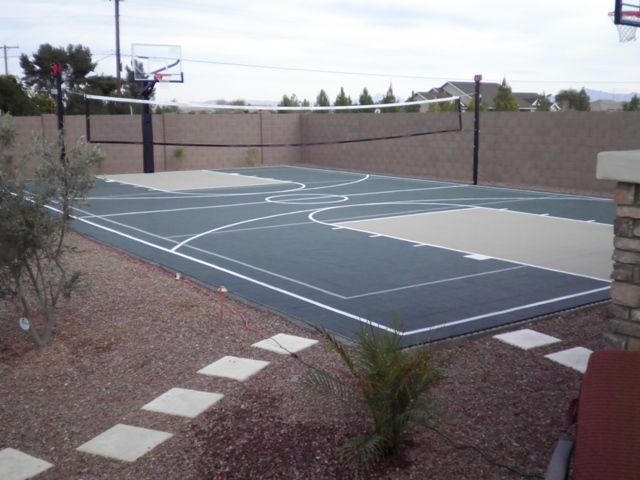 A basketball court with a volleyball net and a basketball hoop