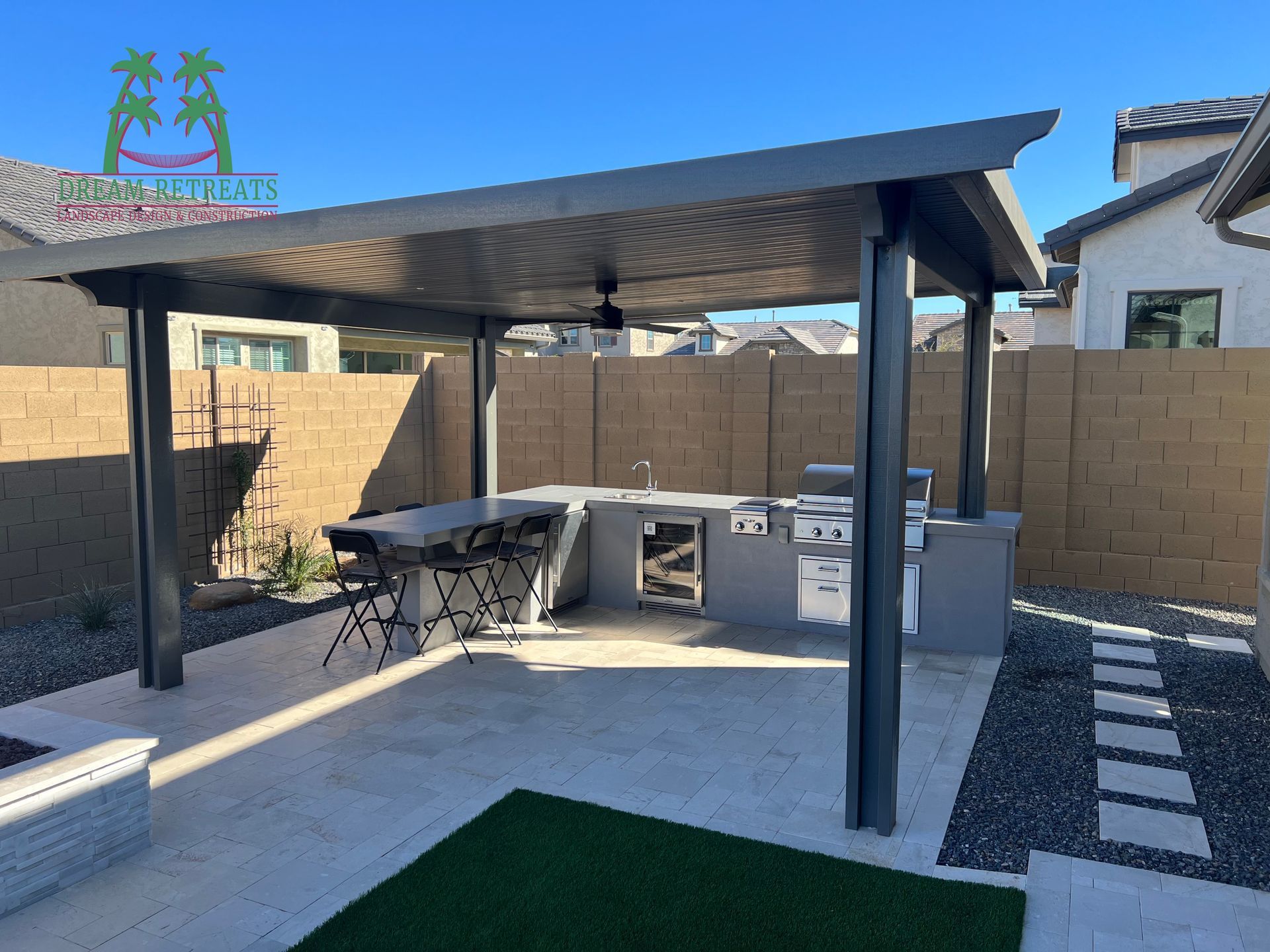 A patio with a pergola and a grill in the backyard
