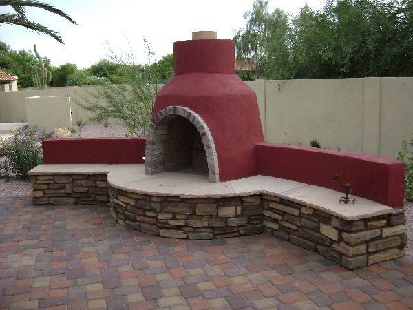 A red fireplace with a stone bench in front of it