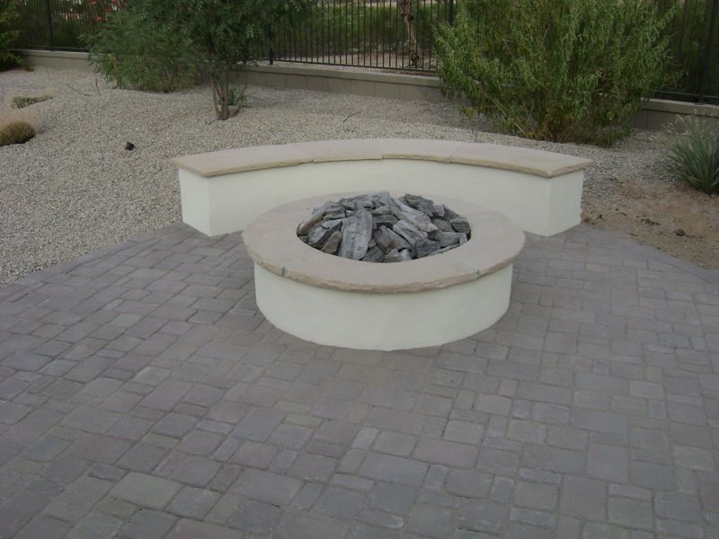 A fire pit is sitting on top of a brick patio.