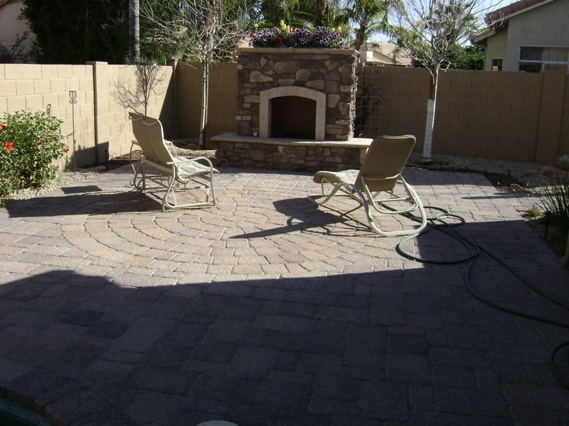 A patio with rocking chairs and a fireplace