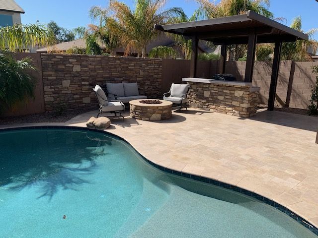 A swimming pool with a fire pit in the middle of it