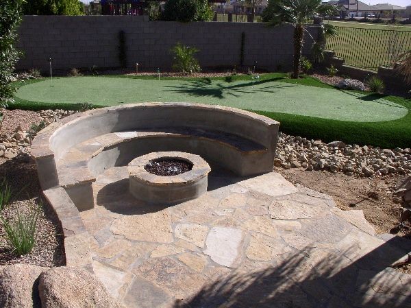 A fire pit sits in front of a green golf course