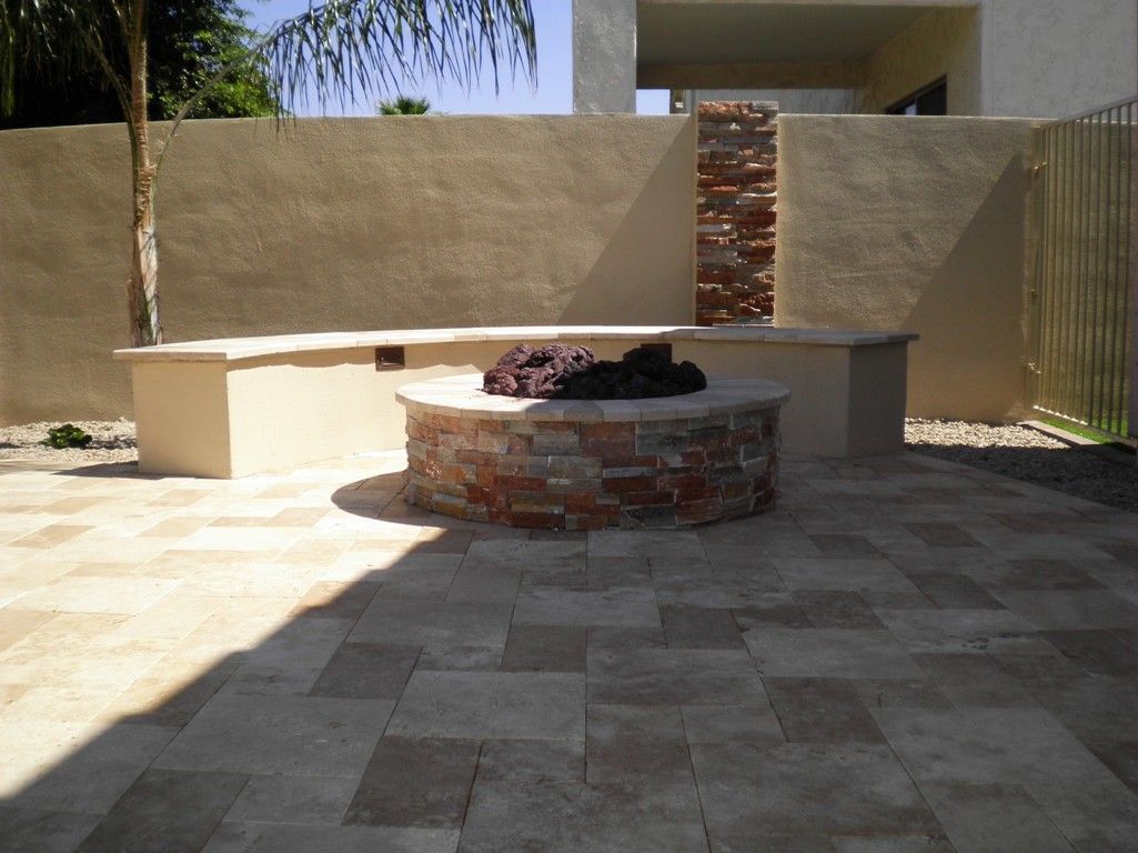A fire pit sits in the middle of a tiled patio
