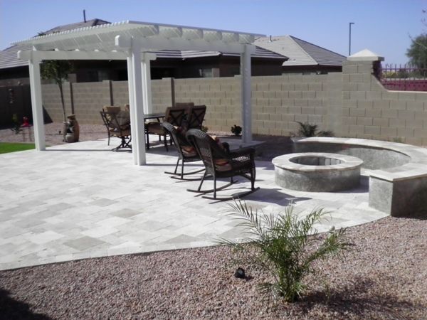 A patio with rocking chairs and a fire pit