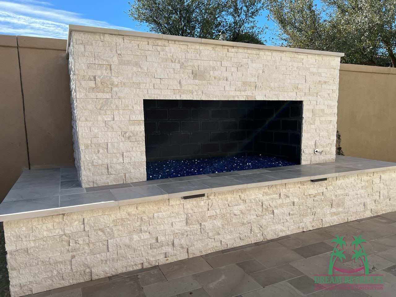 There is a fireplace in the backyard of a house.
