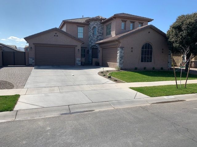 A large house with a concrete driveway in front of it