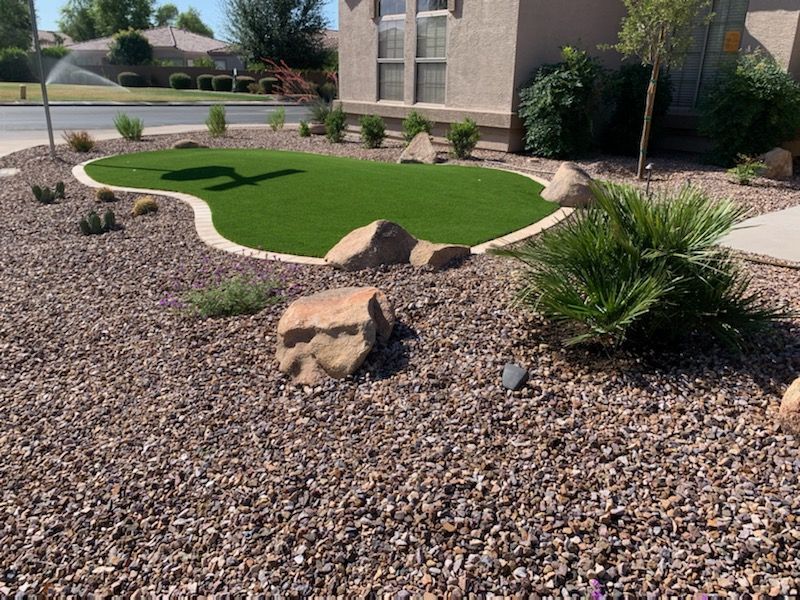 A lawn with rocks and grass in front of a house