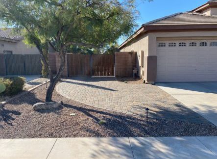 A house with a garage and a fence in front of it.
