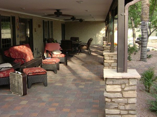 A patio with a lot of furniture and a stone pillar