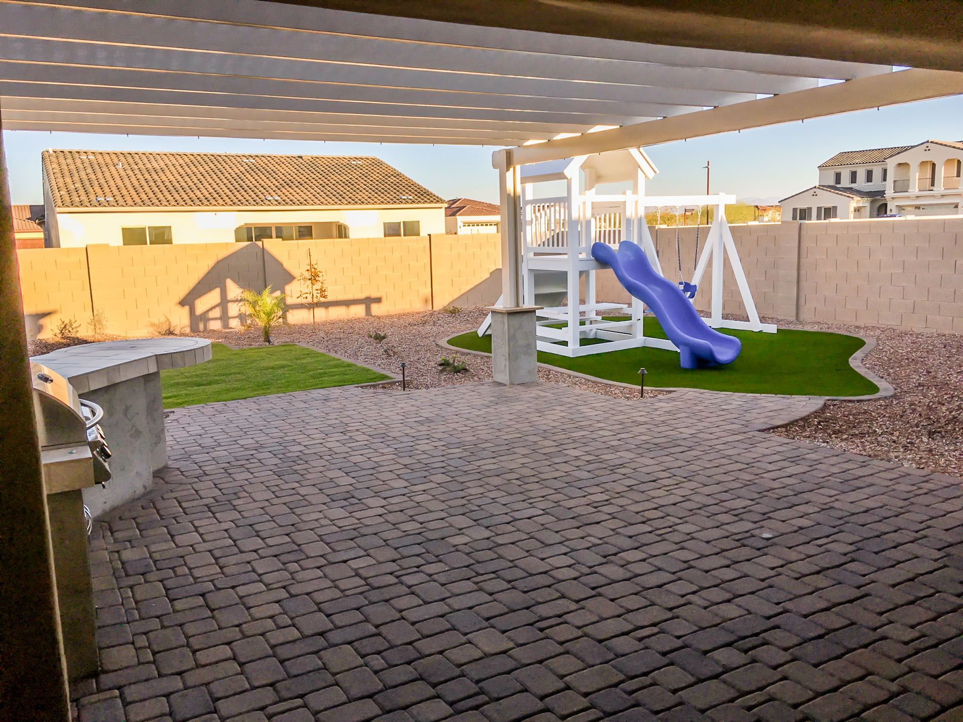 A backyard with a blue slide and a lifeguard tower