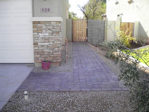 A brick walkway leading to a house with the number 125 on it