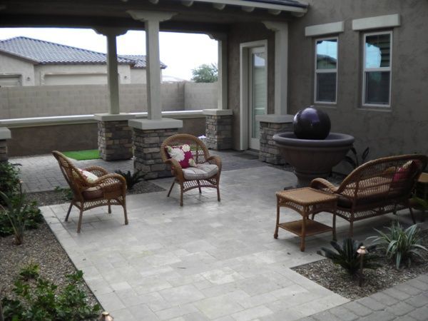 A patio with wicker furniture and a fountain