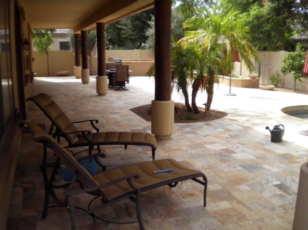 A patio with chairs and a watering can