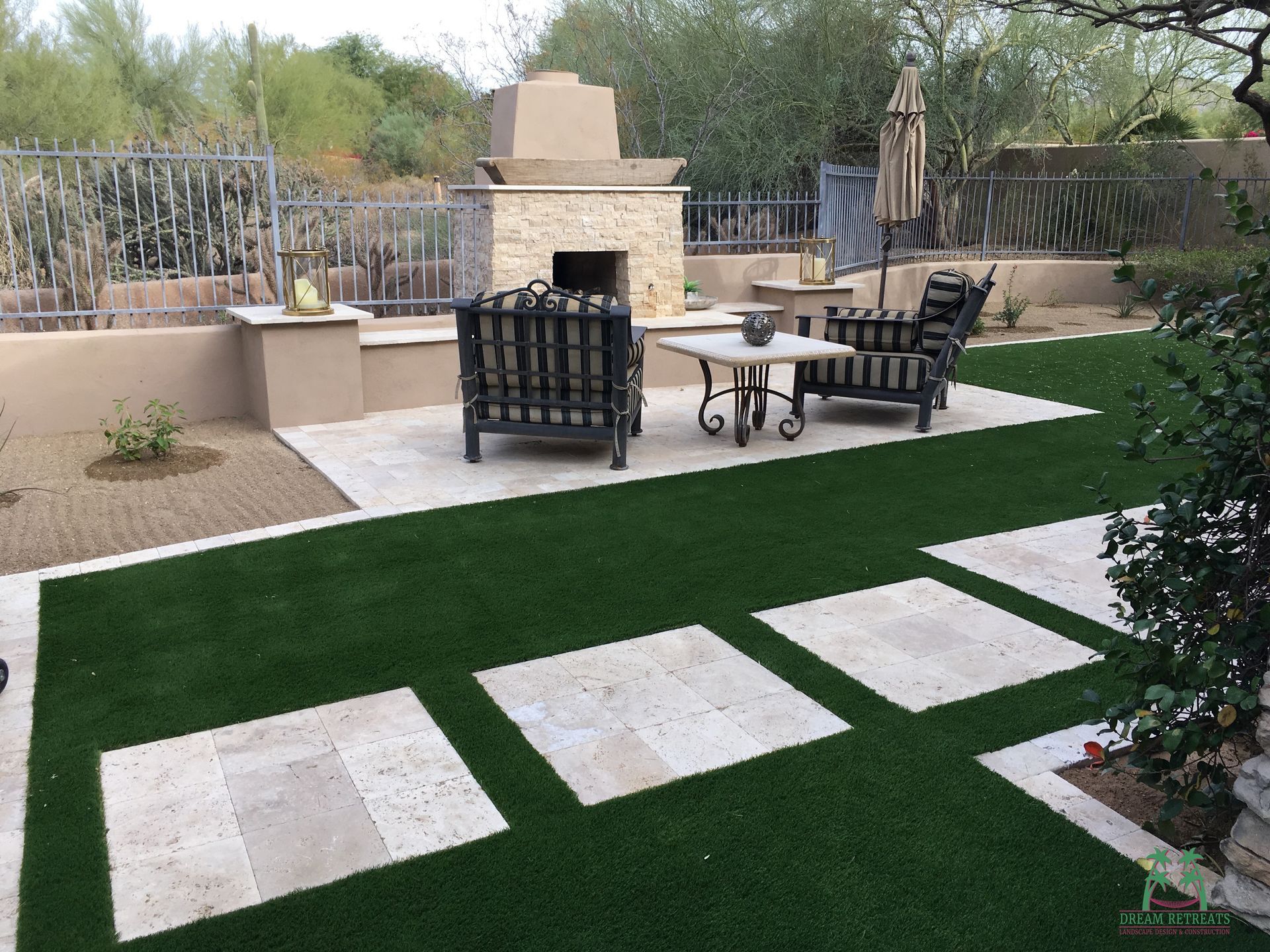 A backyard with a fireplace , chairs and a table