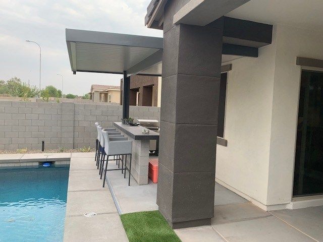 A patio area next to a swimming pool with a table and chairs