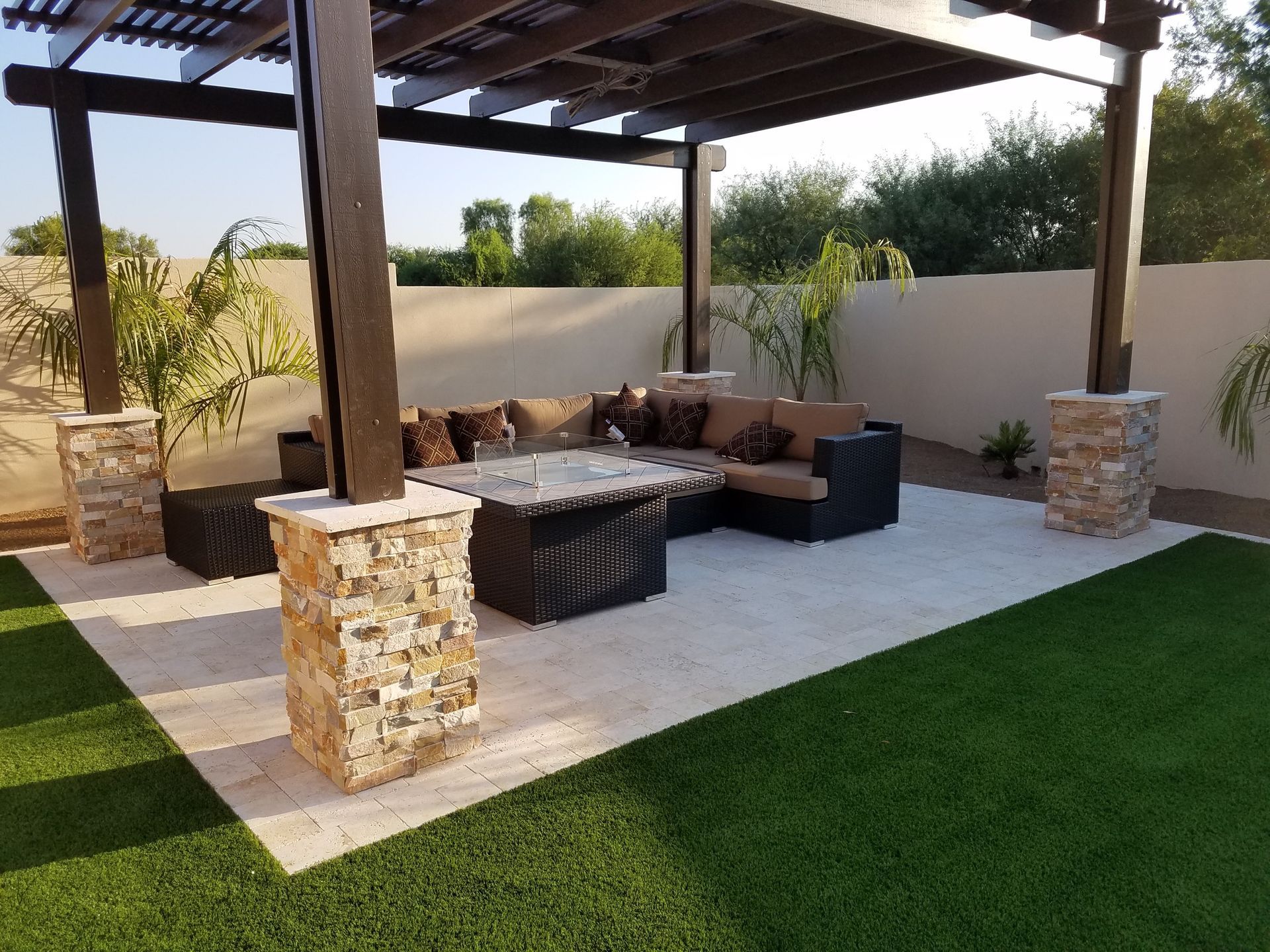 A patio with a pergola and a fire pit