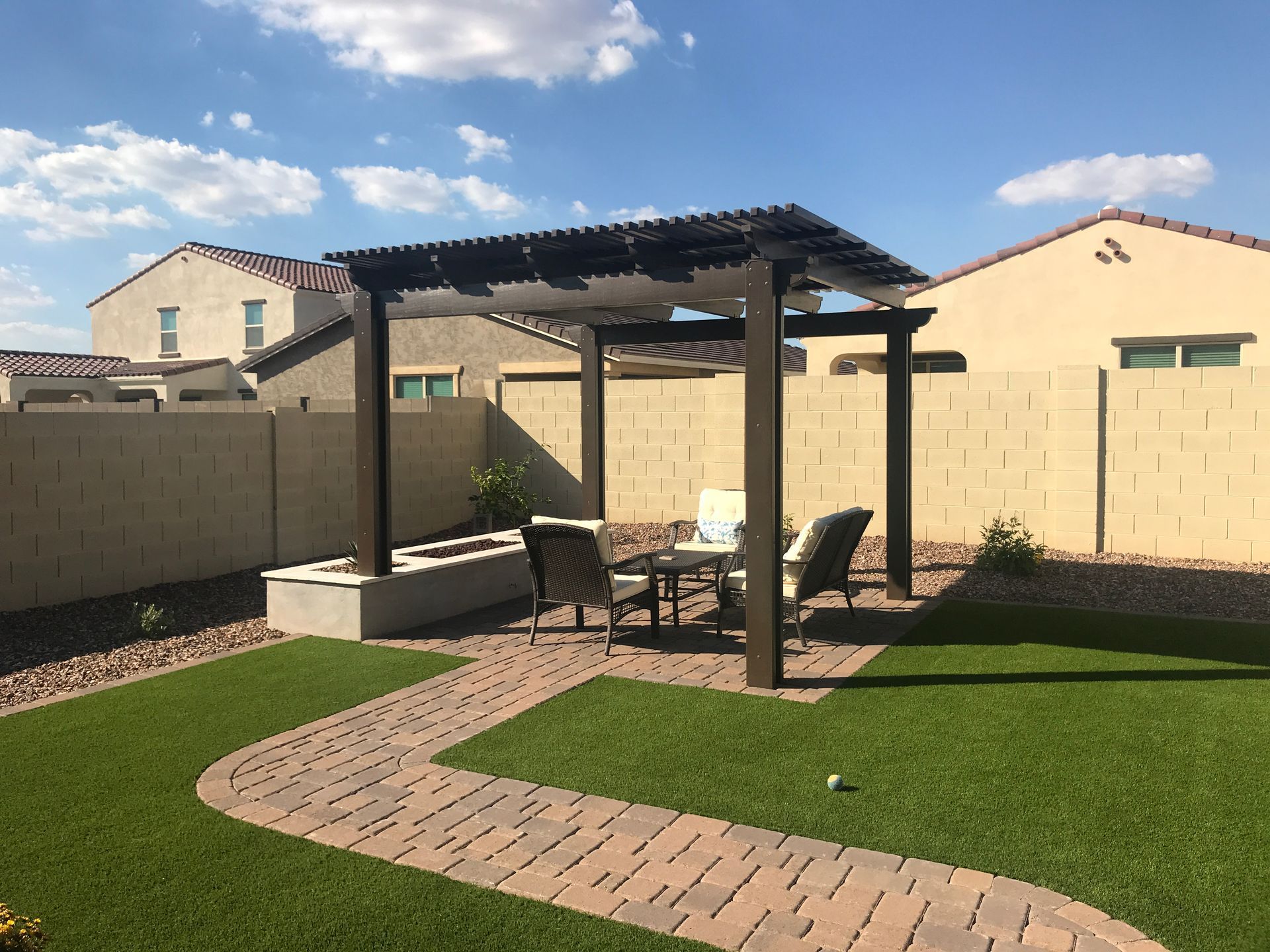 A backyard with a pergola and patio furniture