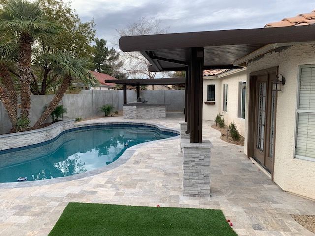There is a swimming pool in the backyard of a house.