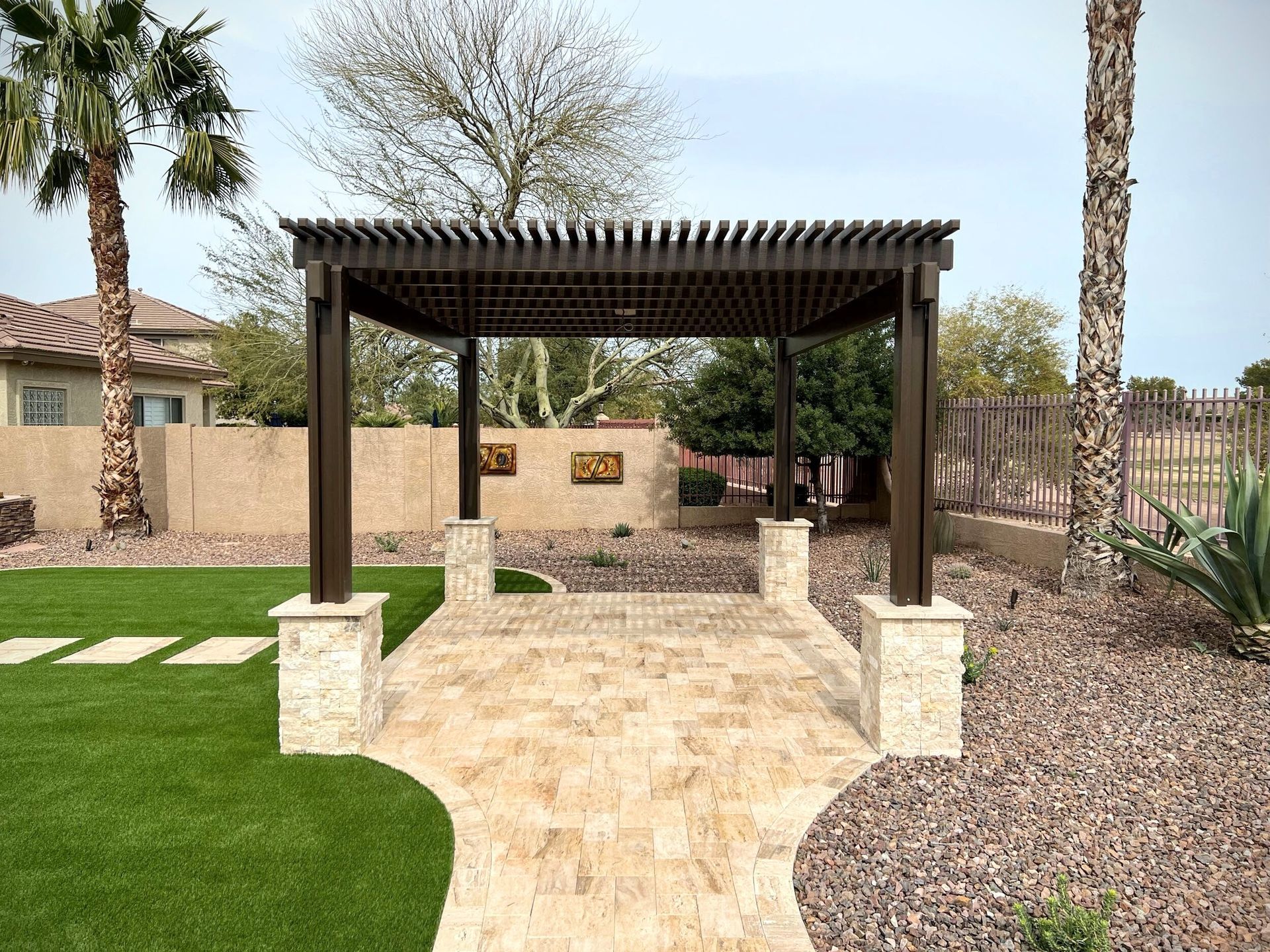 A pergola is sitting in the middle of a lush green backyard.